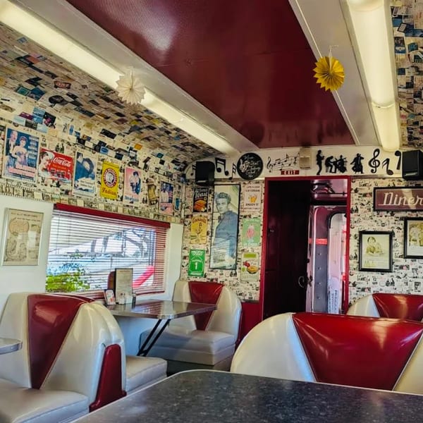 Interior of Rock & Roll Diner with red and white booths, vintage posters, and music decor.